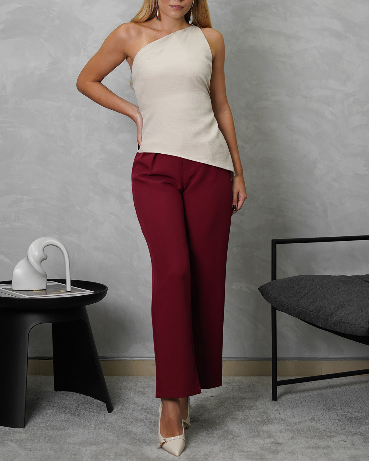 Mujer con blusa asimétrica de espalda escotada beige con pantalon vinotinto