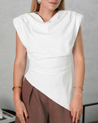 una mujer con blusa asimetrica de hombreras blanca