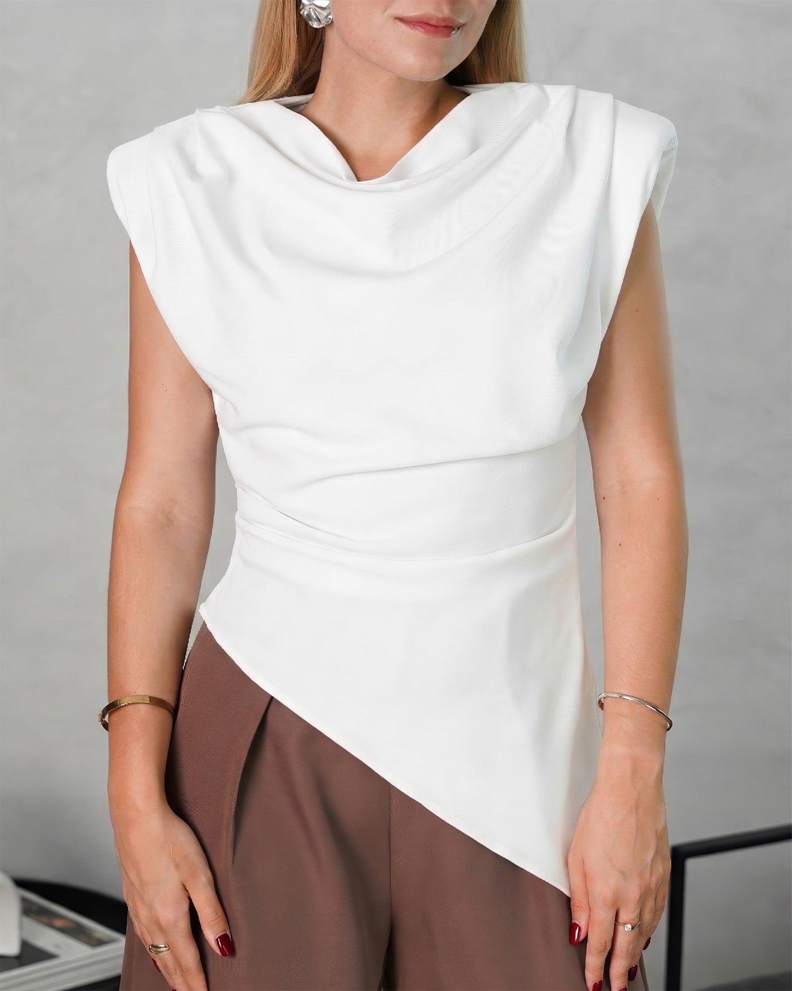 una mujer con blusa asimetrica de hombreras blanca