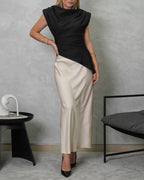 una mujer con blusa asimetrica de hombreras marron y falda de seda beige