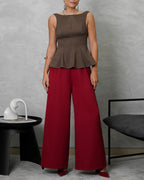 mujer de cuerpo completo usando blusa campanada de espalda escotada marron y pantalon vinotinto