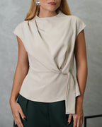 una mujer con blusa campanada de tira colgante beige