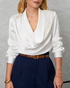 una mujer con blusa de seda manga larga arremangada cuello bobo blanco perla