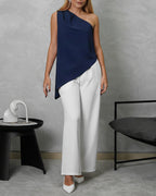 mujer viste de cuerpo completo con blusa holgada asimetrica azul marino y pantalon blanco