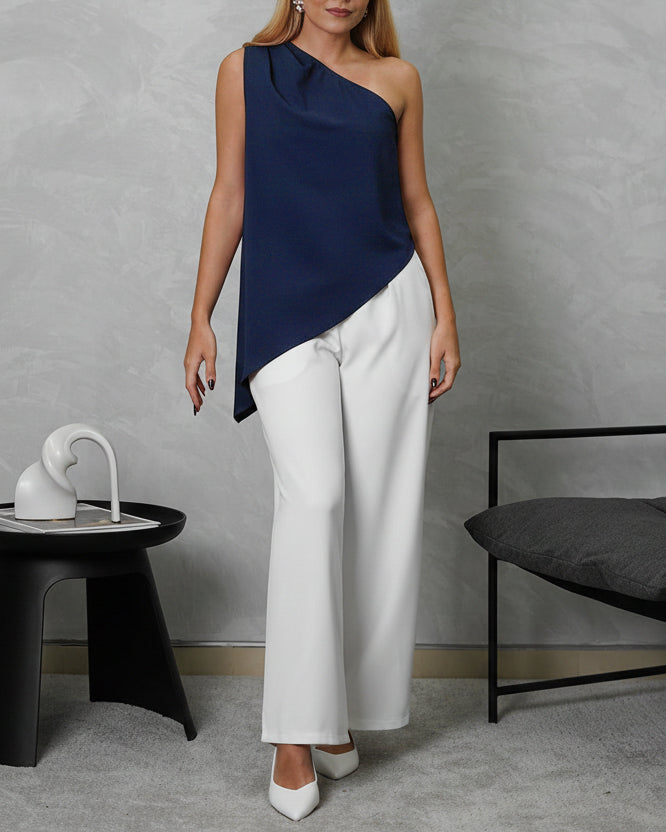 mujer viste de cuerpo completo con blusa holgada asimetrica azul marino y pantalon blanco