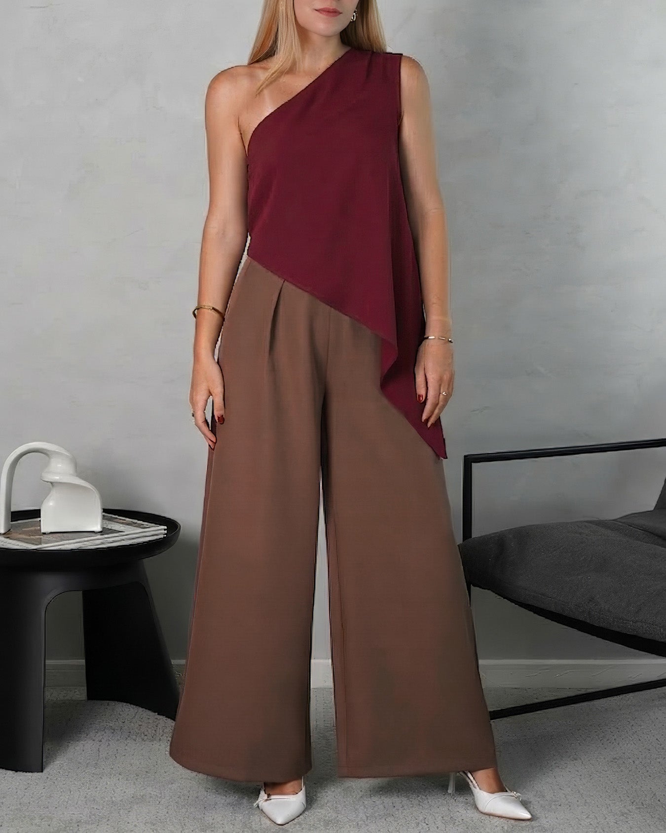 mujer de cerca con blusa holgada asimetrica vinotinto y pantalon marron