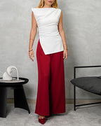 una mujer con una blusa larga corte recto de hombro amarrado blanca y pantalon vinotinto