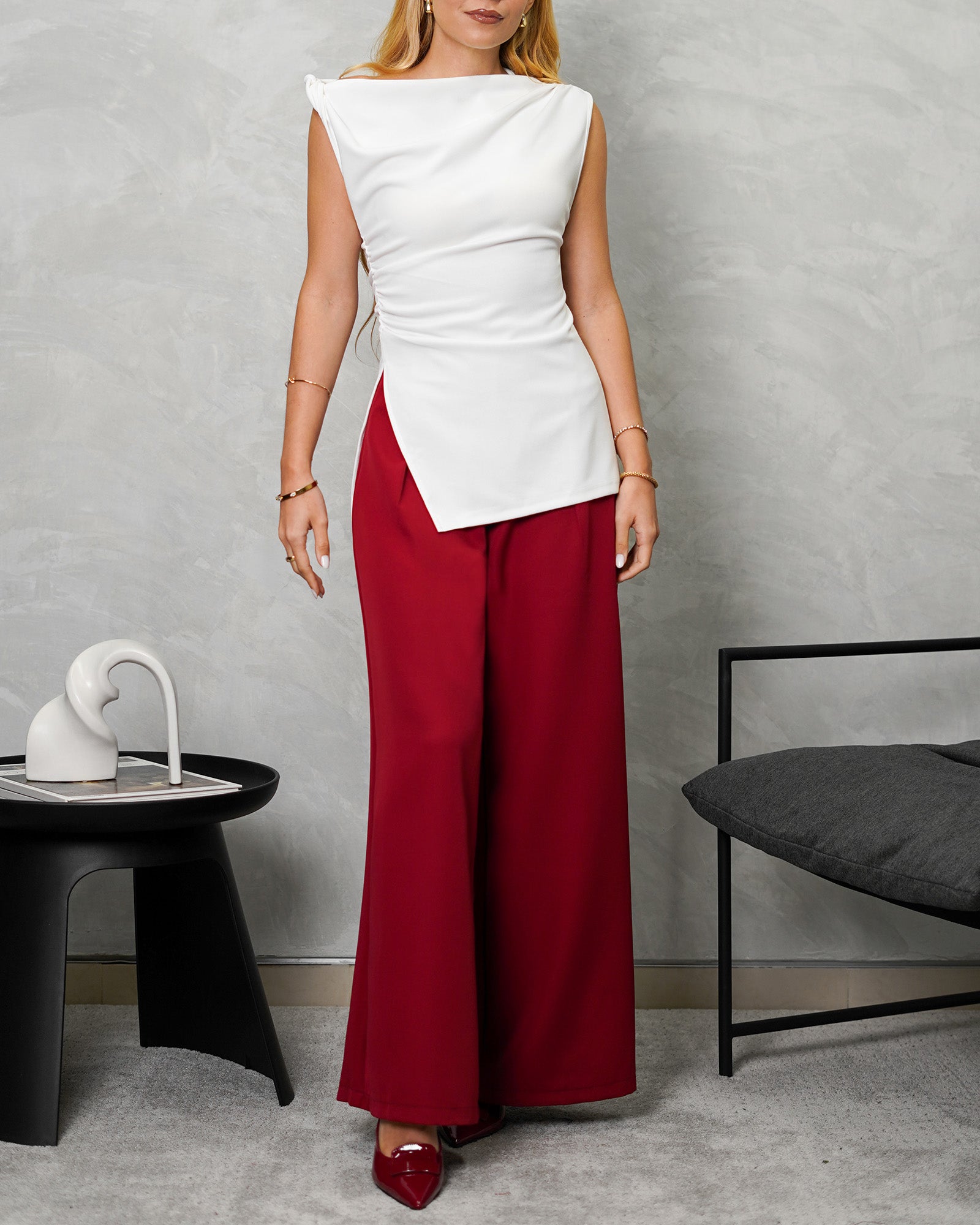 una mujer con una blusa larga corte recto de hombro amarrado blanca y pantalon vinotinto