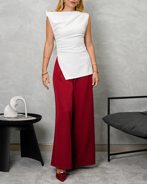 una mujer con una blusa larga corte recto de hombro amarrado blanca y pantalon vinotinto
