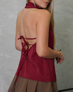 una mujer con blusa sin mangas de dos tiras atras vinotinto