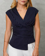 una mujer con blusa sin mangas de rayas verticales azul marino