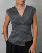 una mujer con blusa sin mangas de rayas verticales gris