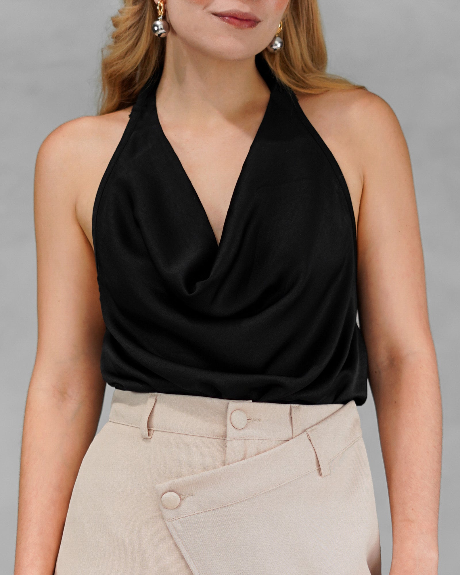 una mujer con una blusa negra sin mangas y espalda abierta 