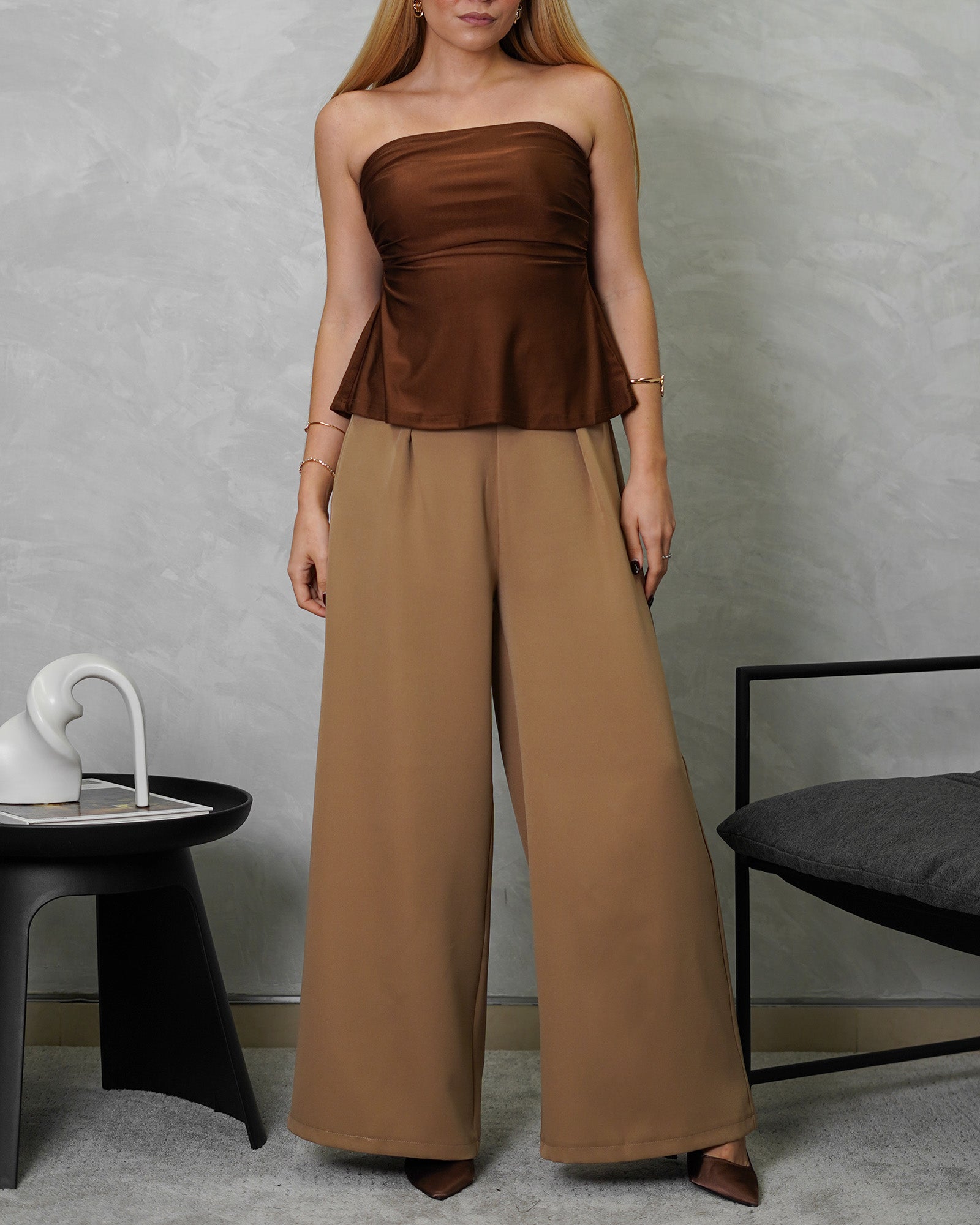 una mujer con Blusa strapless campanada marron satinada y pantalon marron claro