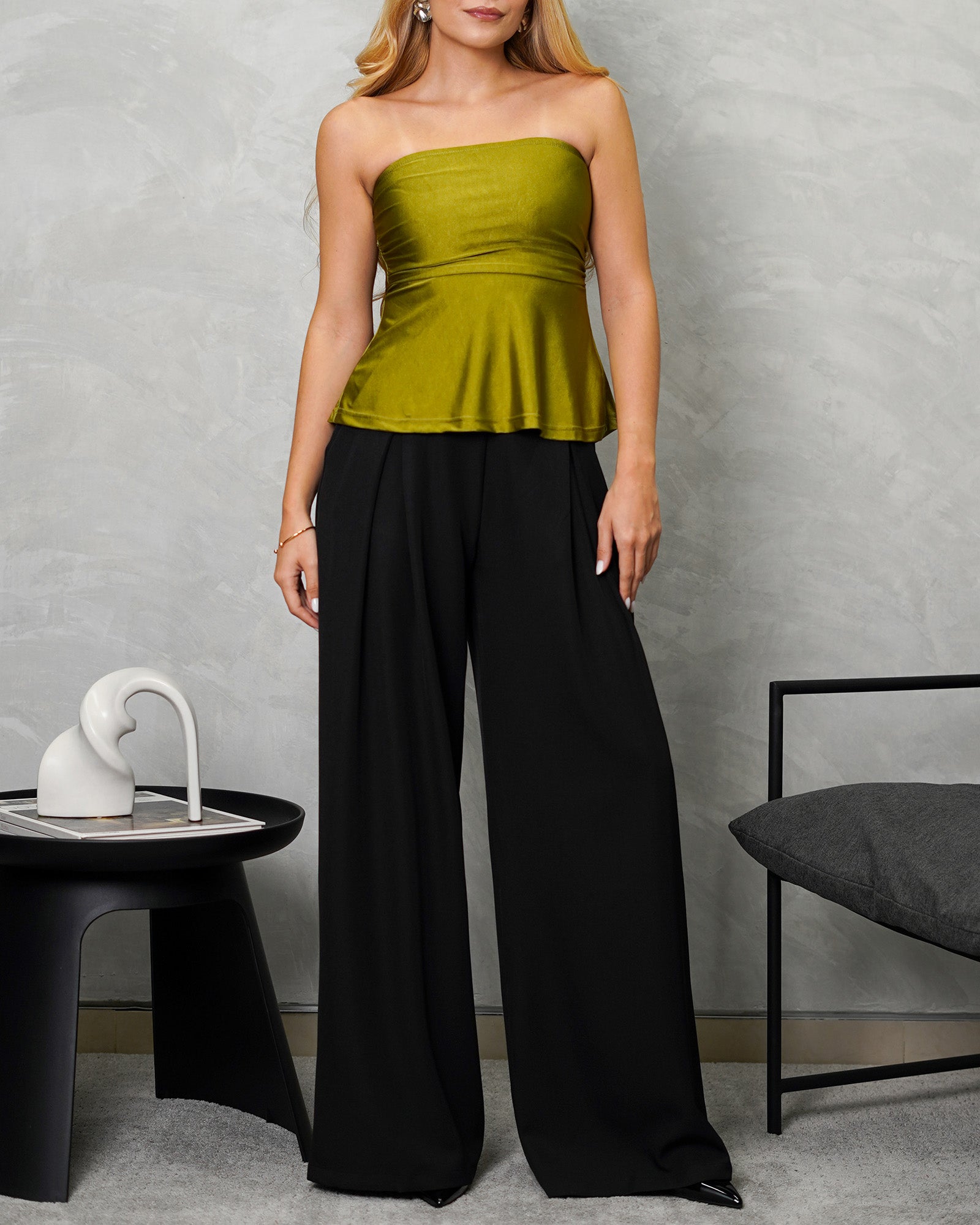 una mujer con Blusa strapless campanada verde satinada y pantalon negro