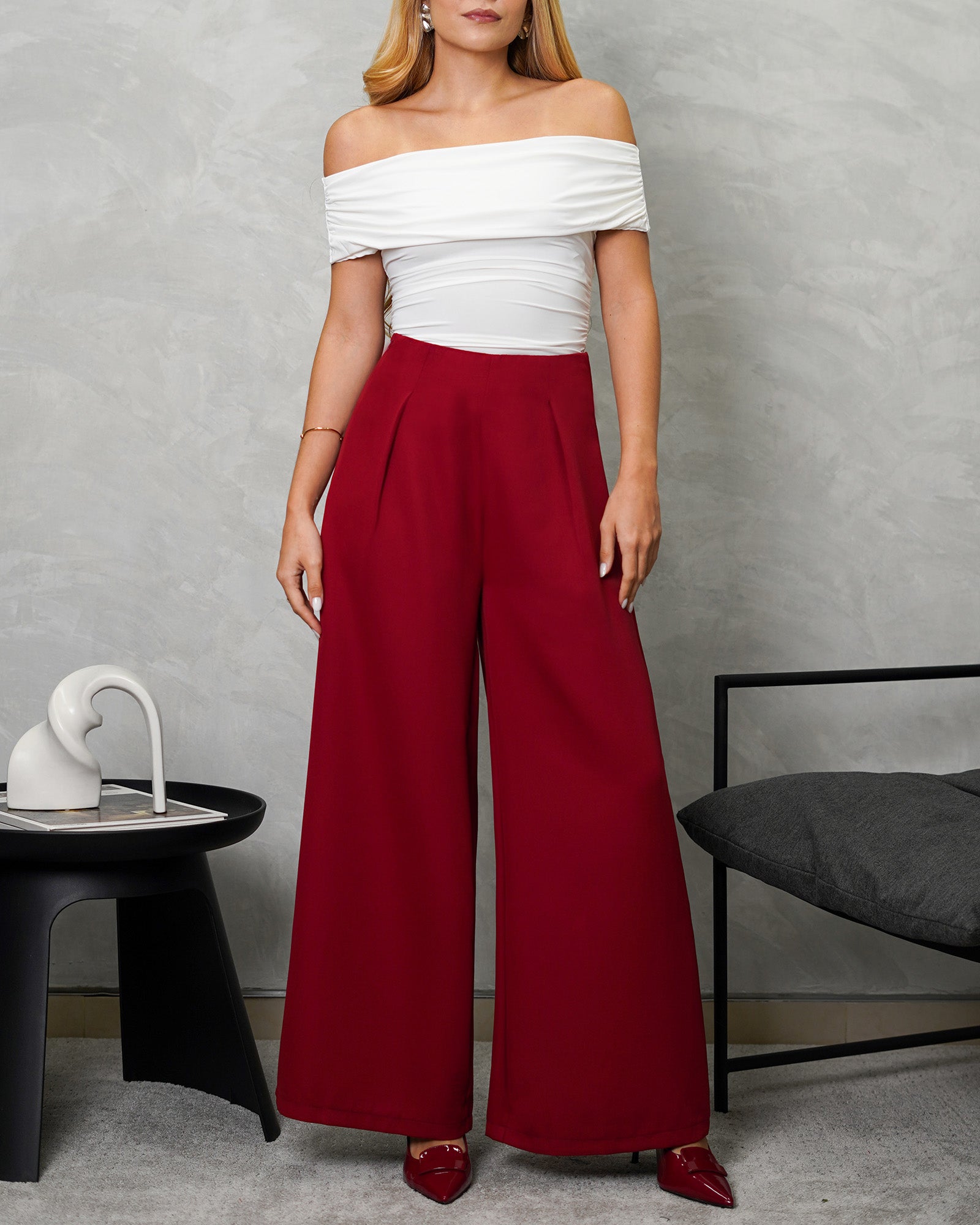 una mujer con un Body off shoulder blanco y pantalon vinotinto