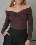 una mujer con un body off shoulder manga larga entrelazado marron 