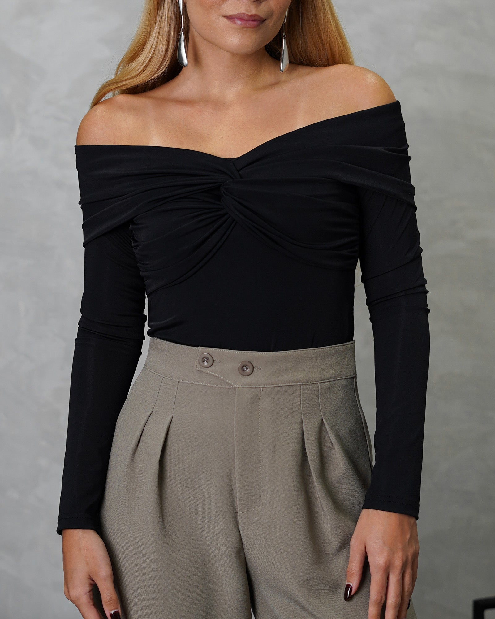 una mujer con un body off shoulder manga larga entrelazado negro 