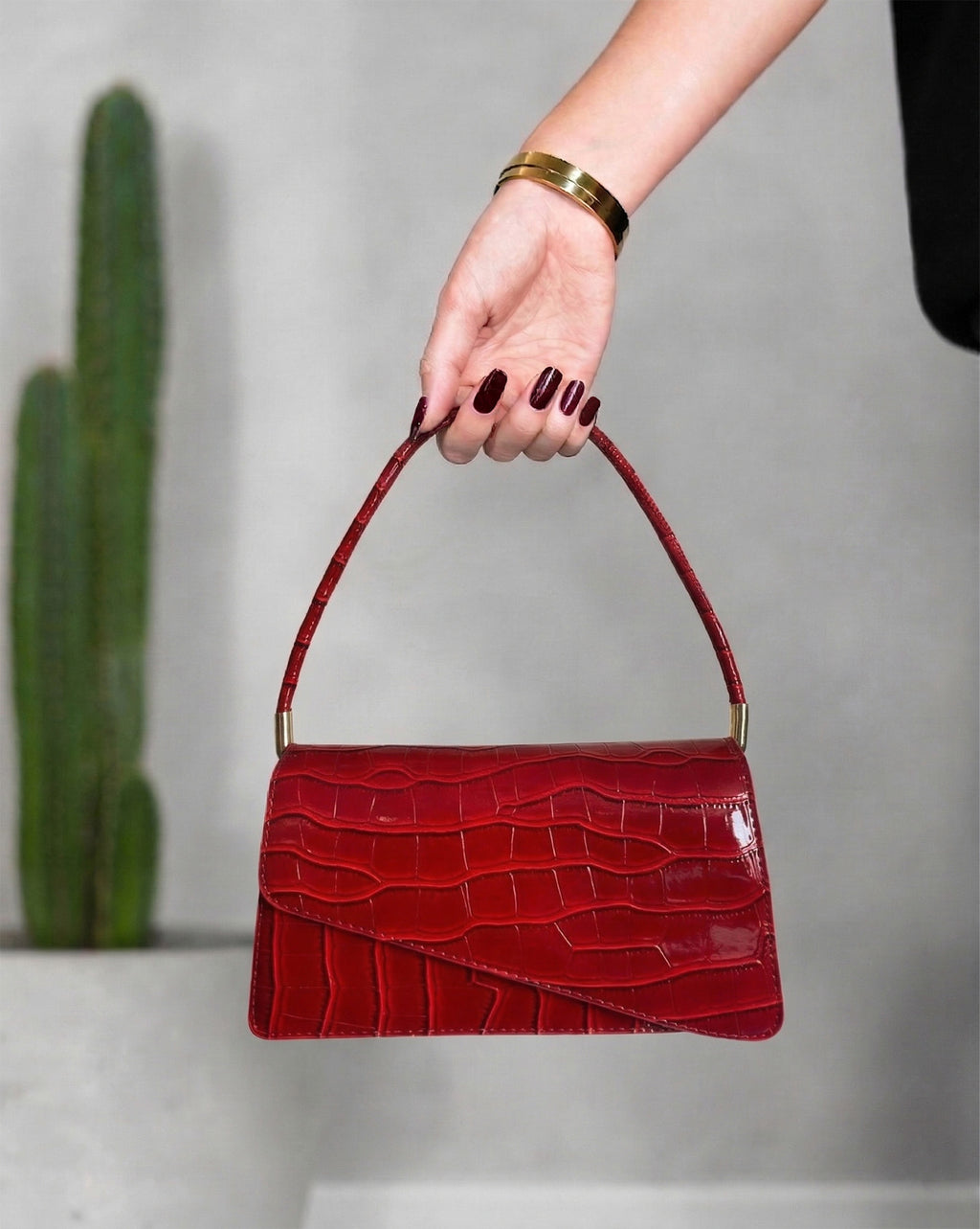 cartera con textura de cocodrilo y solapa asimétrica