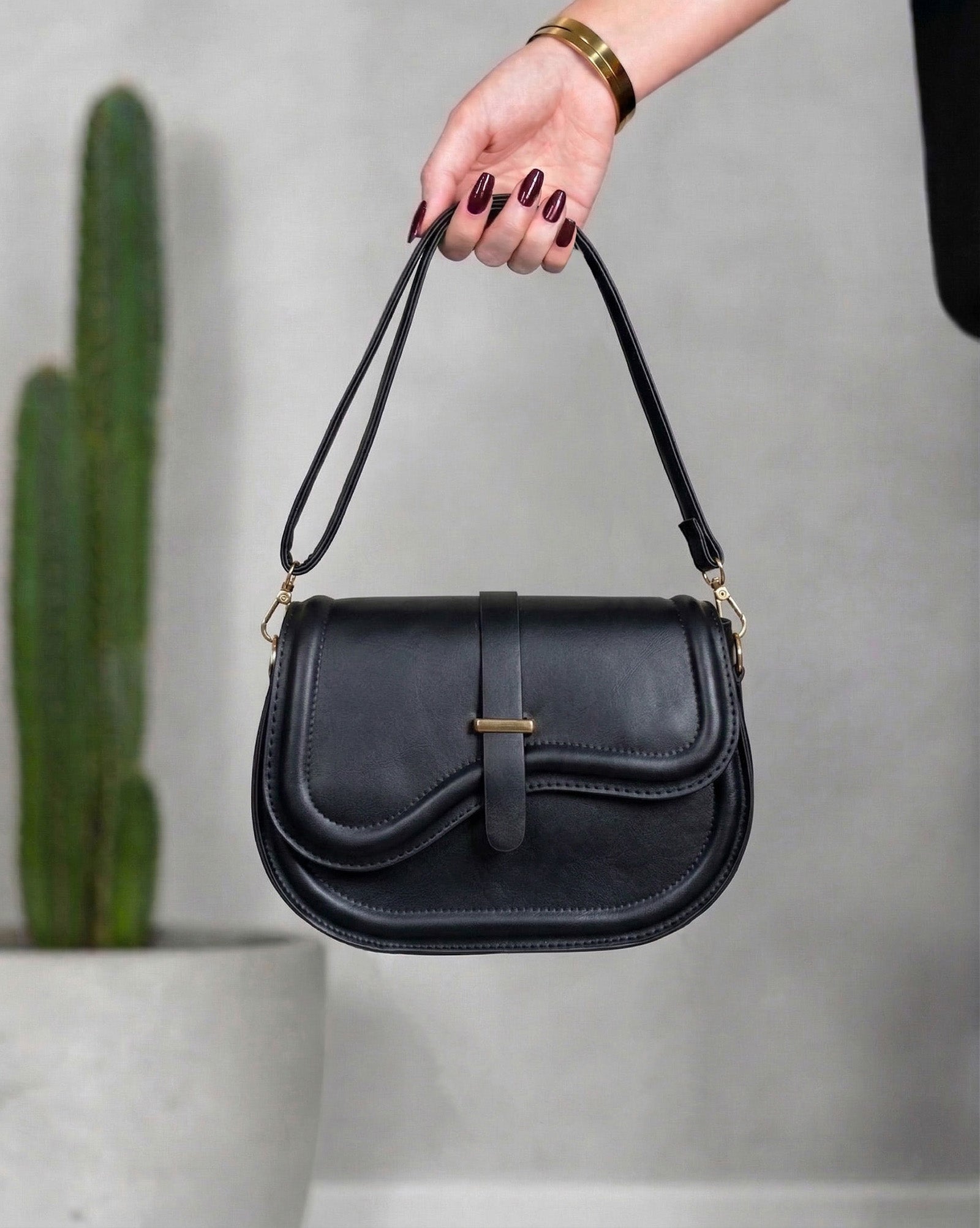 Cartera con solapa de borde ondulado y broche central dorado