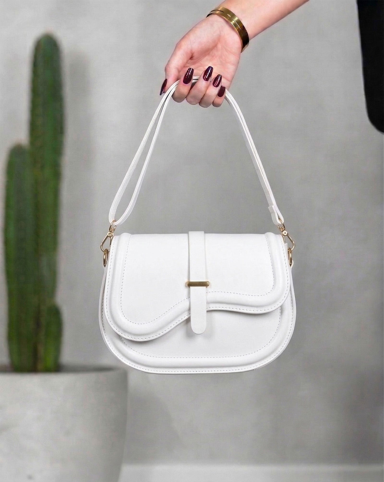 Cartera con solapa de borde ondulado y broche central dorado